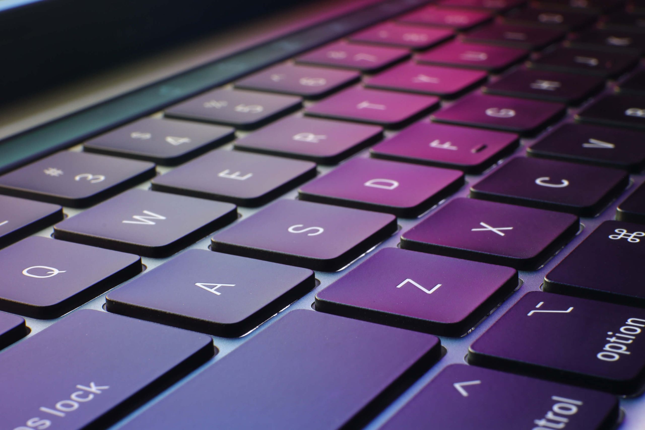 A close up of a keyboard that is reflecting rgb colours